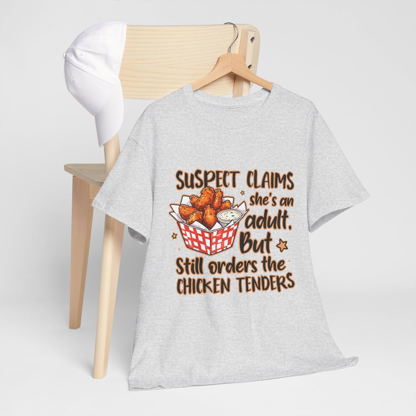 Funny Unisex Heavy Cotton Tee - 'Suspect Claims She's an Adult But Still Orders the Chicken Tenders'