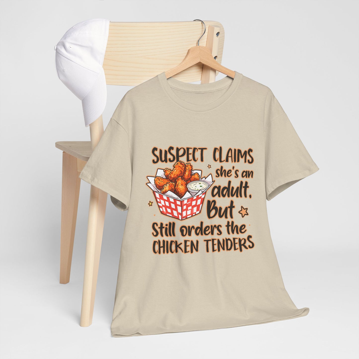 Funny Unisex Heavy Cotton Tee - 'Suspect Claims She's an Adult But Still Orders the Chicken Tenders'