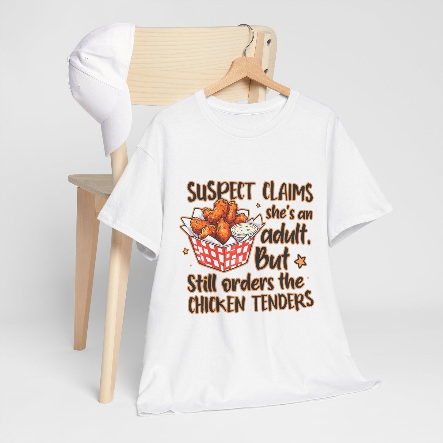 Funny Unisex Heavy Cotton Tee - 'Suspect Claims She's an Adult But Still Orders the Chicken Tenders'